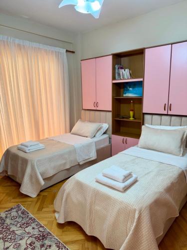 two beds in a room with pink cabinets at Shkodra Central in Shkodër