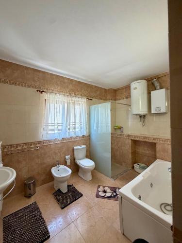 a bathroom with a toilet and a sink and a tub at Shkodra Central in Shkodër