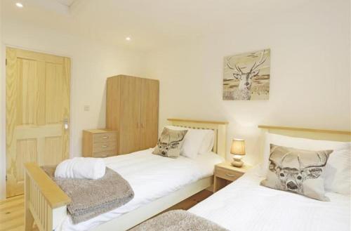 a bedroom with two beds and a picture on the wall at Greenacres in Kelsale
