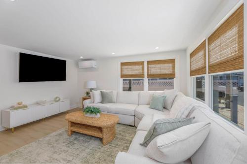 a living room with a white couch and a tv at Mermaid Lane #1 in Brighton Beach