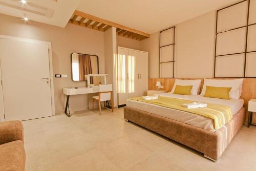 a large bedroom with a bed and a desk at Hotel Hills in Donji Štoj