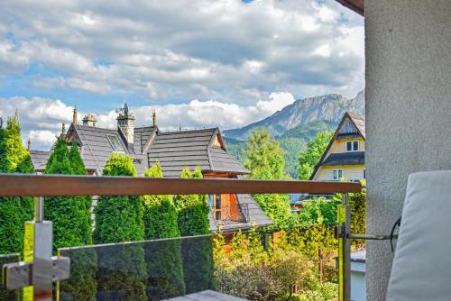 a balcony with a view of a house at Apartamenty Widokowe Pod Lasem in Kościelisko