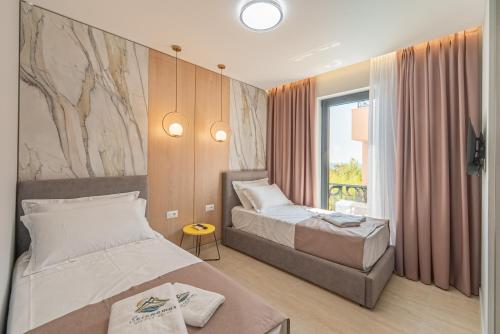 a hotel room with two beds and a window at Evianamar in Shëngjin