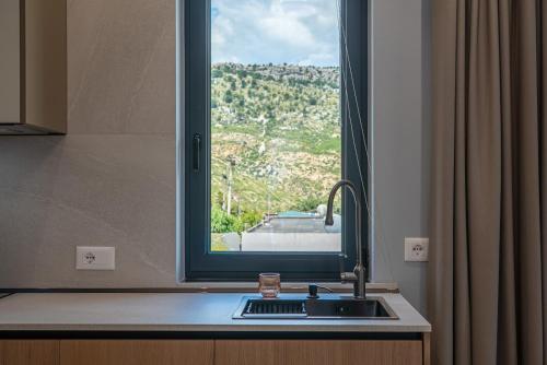 a kitchen sink with a window with a view at Evianamar in Shëngjin