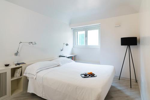 a white bedroom with a bed and a window at The Seven Mansions in Genoa