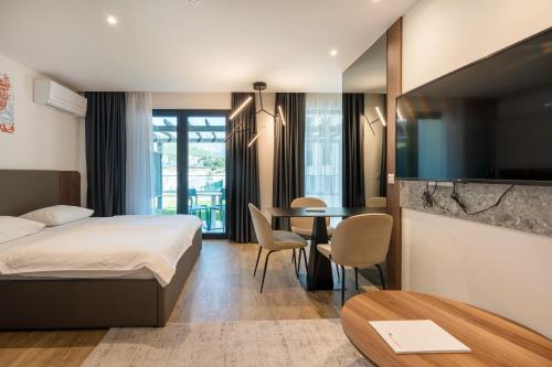 a hotel room with a bed and a table at Amfora-modern apartments with pool in Makarska