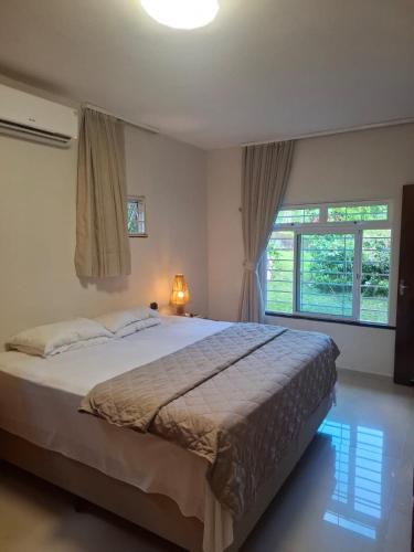 a bedroom with a large bed and a window at Sítio Quinta da Serra in Guaramiranga