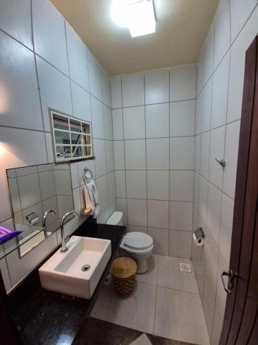 a white bathroom with a sink and a toilet at Sítio Quinta da Serra in Guaramiranga