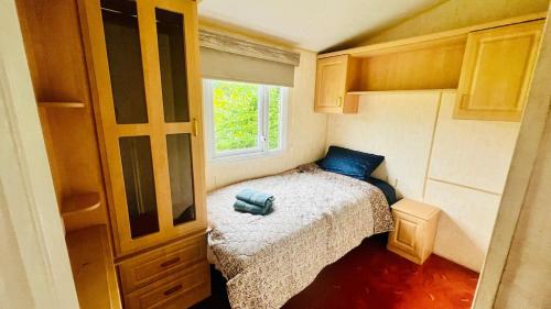 a small bedroom with a bed and a window at The Hidden Meadow in Ballybofey
