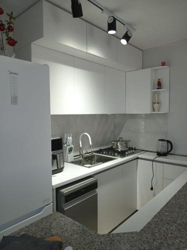 a white kitchen with a sink and a stove at Chakvi hotel in Chakvi