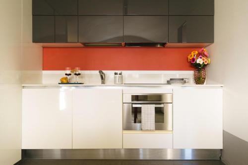 a kitchen with white cabinets and a sink at The Seven Mansions in Genoa
