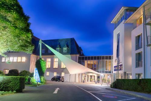a building with a large tent in the middle of a street at Welcome Hotel Meschede Hennesee in Meschede