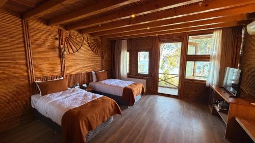 a hotel room with two beds and a television at Diamond Koru Hotel in Amasra