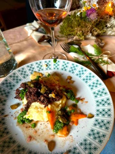 a plate of food on a table with a glass of wine at Cihelna 10 Teepee&Wine in Hlavňovice