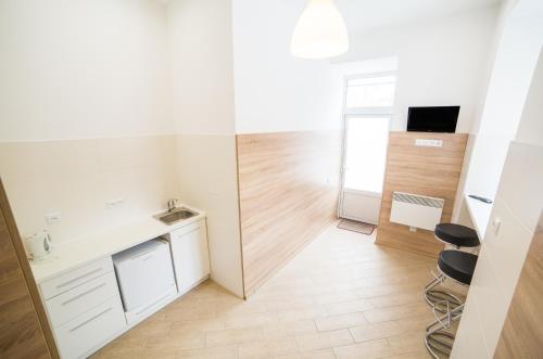 a small white kitchen with a counter and stools at Mini Apartment on Kulisha 29-3 in Lviv