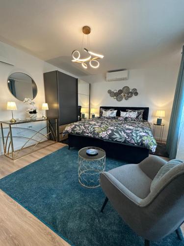 a bedroom with a bed and a couch and a chair at Apartman NOA in Novska