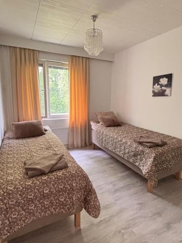 a bedroom with two beds and a chandelier at Hamina Comfort Apartment in Hamina