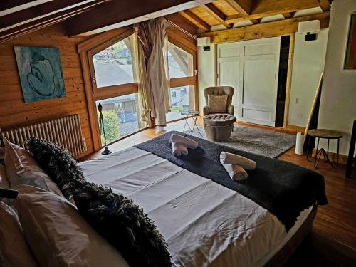 a large bed in a room with a large window at Large Superior Style Chalet - Central Location in Morzine