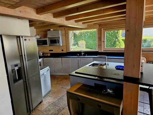 a kitchen with a stainless steel refrigerator in a cabin at Large Superior Style Chalet - Central Location in Morzine