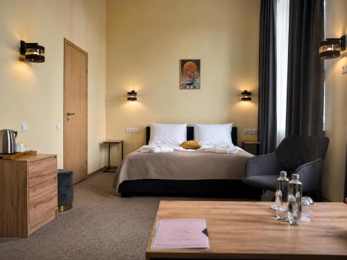 a hotel room with a bed and a chair and a table at Mangal Hotel in Olgina