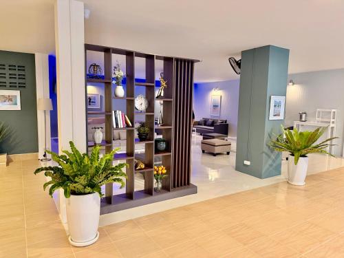 a living room with potted plants in a room at THE BEACH INN Cha-Am in Cha Am