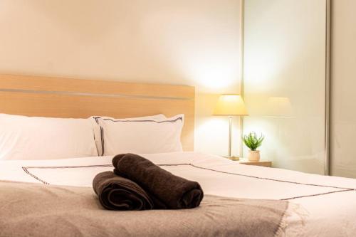 a large white bed with a towel on it at Koala Nest Central Adelaide 1BR Apartment with Pool & Sauna - Koala Stay in Adelaide