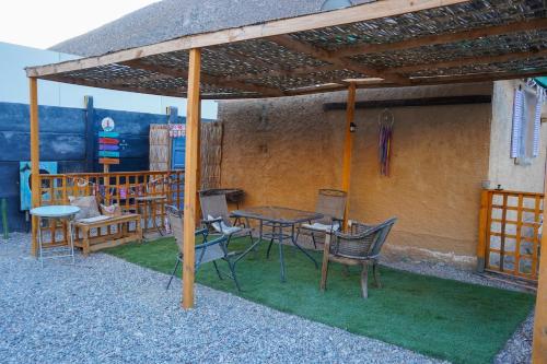 a patio with a table and chairs under a roof at Río Luna cabaña 2 in Diaguita