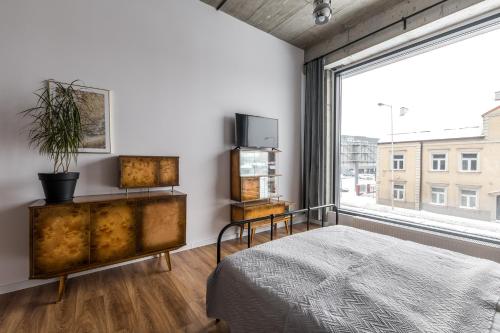 a bedroom with a bed and a large window at Gold and Silver Apartment - Manu SPA Lofts in Łódź