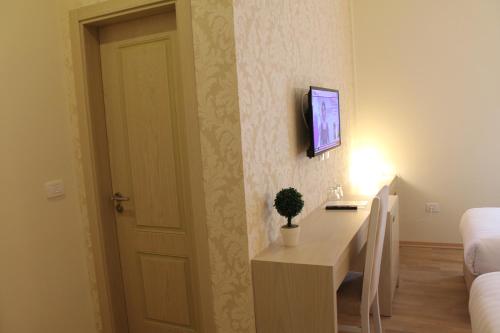 a room with a desk and a tv on a wall at Capital Tirana Hotel Bruçi in Tirana