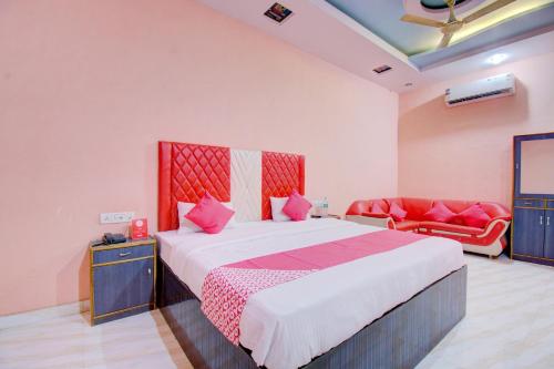 a bedroom with a large bed and a red couch at 6 CR Hotel Lucky Star CENTRAL BUS STOP in Aurangabad
