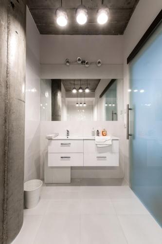 a bathroom with a sink and a toilet at Gold and Silver Apartment - Manu SPA Lofts in Łódź