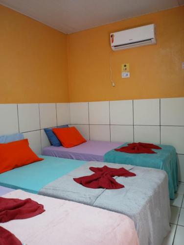 a room with three beds in a room at Pousada Açaí in Salvaterra