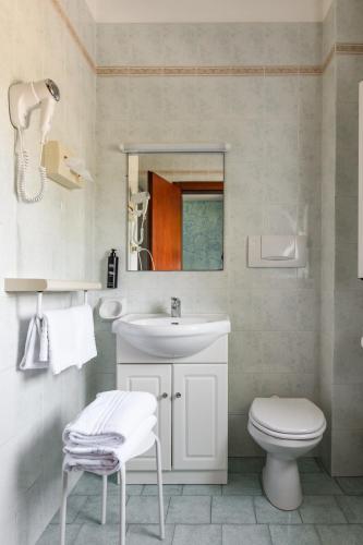 a bathroom with a sink and a toilet and a mirror at Hotel L'Approdo in Casamicciola Terme