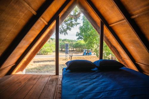 a bed in a tent with a large window at Wild Roots Cabana Arugambay in Arugam Bay