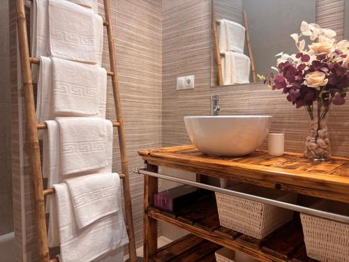 a bathroom with a sink and a mirror and towels at El rincón de San Bartolomé in Jerez de los Caballeros