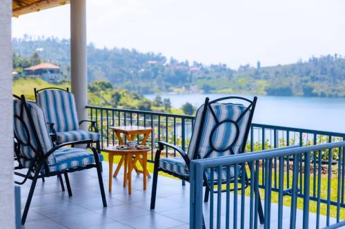 three chairs and a table on a balcony with a view at Mariebu Beach Resort in Buhongo