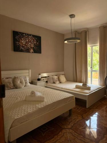 a bedroom with two beds and a window at Pensão Simão & Júlia - 8 Quartos in Órgãos