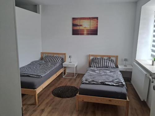 a room with two beds and a picture on the wall at Self Check-in Apartment DLT - Free Parking in Sankt Marein im Mürztal