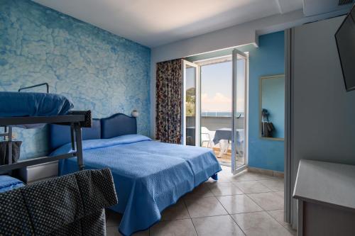 a blue bedroom with a bed and a balcony at Hotel L'Approdo in Casamicciola Terme