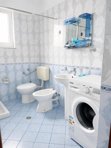 a bathroom with a toilet sink and a washing machine at Villa Ajla- Entire Villa in Durrës