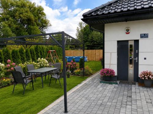 a patio with a table and chairs in a yard at Villa Kraków in Krakow