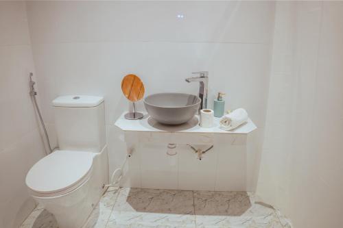 a white bathroom with a sink and a toilet at Neem Tree Boutique Resort in Serukele