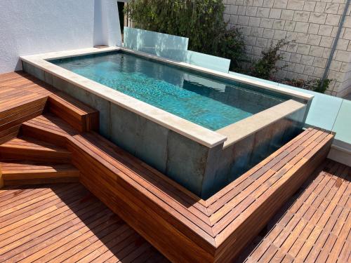 a pool on a deck with a wooden floor and stairs at Belado Residence Bol in Bol