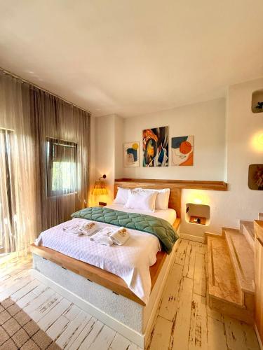 a bedroom with a large bed and a window at Dione Bozcaada in Bozcaada