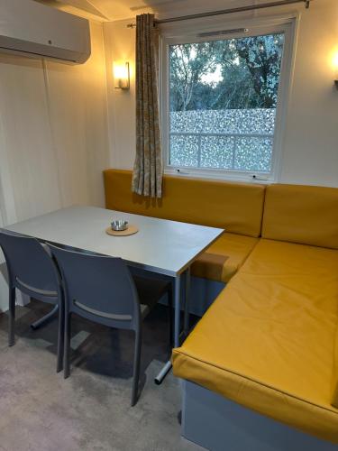 a dining room with a table and chairs and a window at camping les dolmens in Méjannes-le-Clap