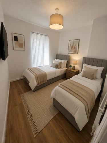 a bedroom with two beds and a television in it at Brennan stays contractor professional Friendly in Liverpool