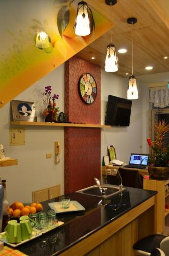 a kitchen with a counter with a sink and a clock at Grapefruit Heping Guesthouse in Hualien City