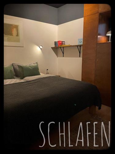 a bedroom with a bed with a black comforter at Gemütliches Apartment mit Moselblick in Reil
