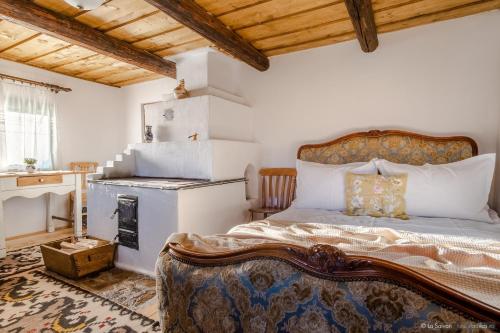 a bedroom with a bed and a stove at HANUL BUCOVINEI in Câmpulung Moldovenesc
