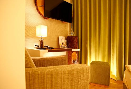 a living room with a couch and a television and a chair at Flair Hotel Nieder in Bestwig